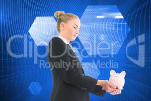 Composite image of businesswoman holding piggy bank