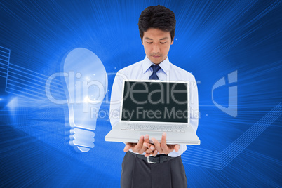 Composite image of businessman showing a laptop