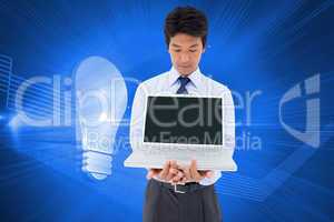 Composite image of businessman showing a laptop