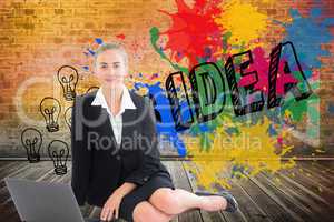 Composite image of businesswoman using laptop