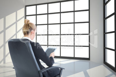 Composite image of businesswoman sitting on swivel chair with ta