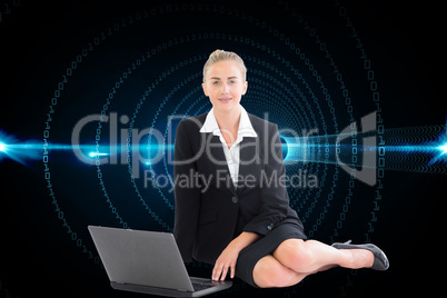 Composite image of businesswoman using laptop