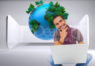 Composite image of thinking man sitting on floor using laptop an