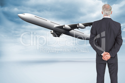 Composite image of rear view of serious businessman posing