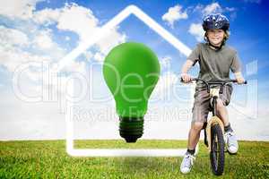 Composite image of little boy with his bike in a park