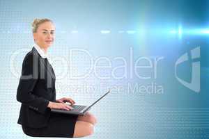 Composite image of businesswoman using laptop