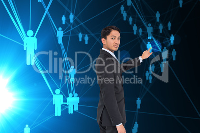 Composite image of serious asian businessman pointing