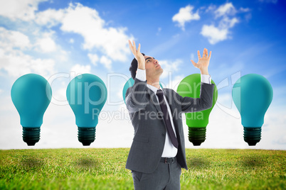 Composite image of unsmiling businessman with arms raised