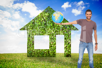 Composite image of handsome man holding out a globe