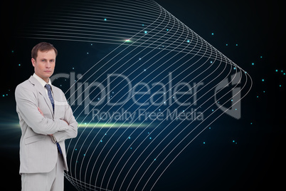 Composite image of serious businessman standing with his arms fo