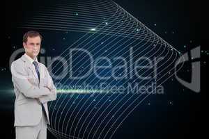Composite image of serious businessman standing with his arms fo
