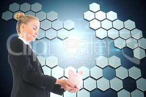 Composite image of businesswoman holding piggy bank