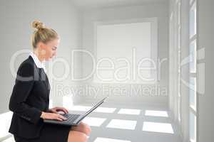 Composite image of businesswoman using laptop