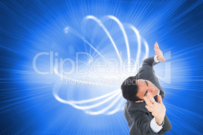 Composite image of unsmiling businessman with arms raised