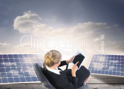 Composite image of businesswoman sitting on swivel chair with ta