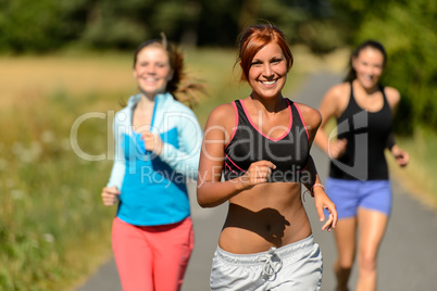 three friends running outdoors smiling