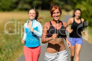 three friends running outdoors smiling