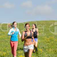 friends enjoy running through sunny meadow