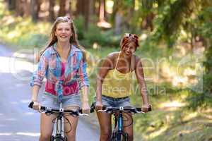 two teenage girls riding their bikes