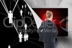 Composite image of businesswoman standing with hands on hips