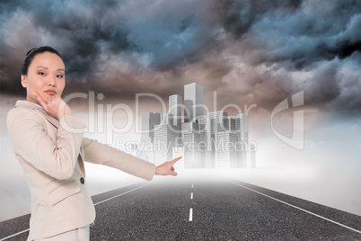 Composite image of thoughtful asian businesswoman pointing