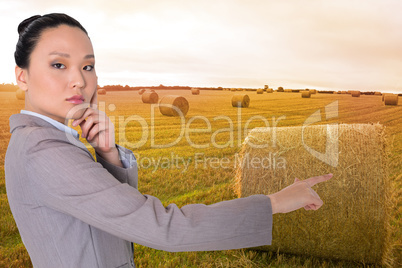 Composite image of thoughtful asian businesswoman pointing