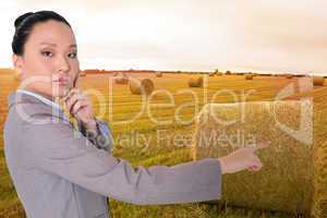 Composite image of thoughtful asian businesswoman pointing