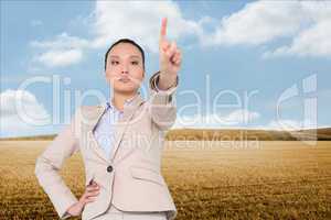 Composite image of unsmiling asian businesswoman pointing