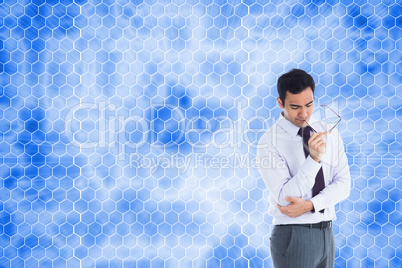 Composite image of thinking businessman holding glasses