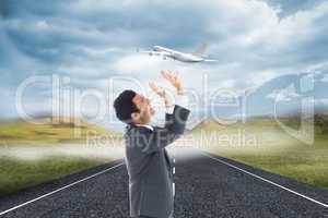 Composite image of scared businessman with arms raised