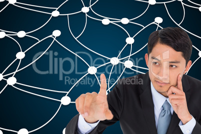 Composite image of thoughtful asian businessman pointing