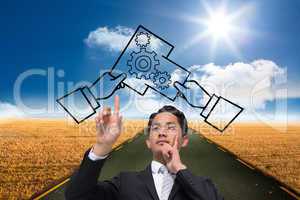 Composite image of thoughtful asian businessman pointing