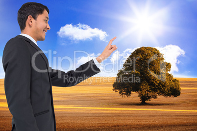 Composite image of smiling asian businessman pointing