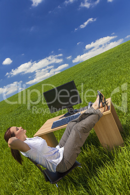 woman relaxing at office desk in green field