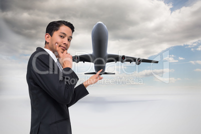 Composite image of thoughtful asian businessman pointing