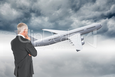 Composite image of thoughtful businessman standing back to camer