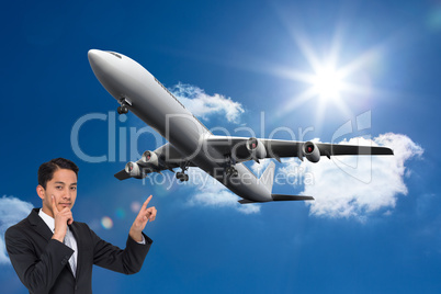 Composite image of thoughtful asian businessman pointing