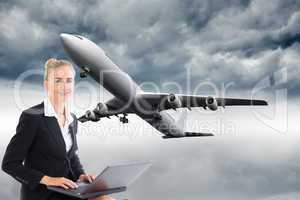 Composite image of businesswoman using laptop