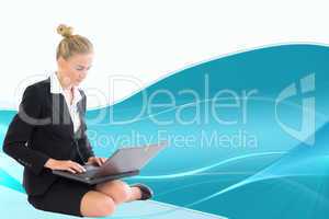 Composite image of businesswoman using laptop