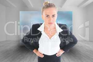 Composite image of businesswoman standing with hands on hips