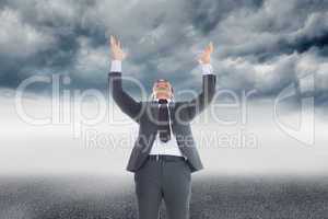 Composite image of businessman with arms raised