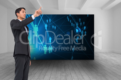 Composite image of serious asian businessman pointing