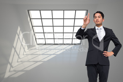 Composite image of unsmiling asian businessman pointing