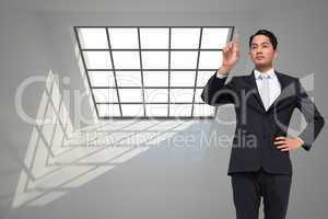 Composite image of unsmiling asian businessman pointing