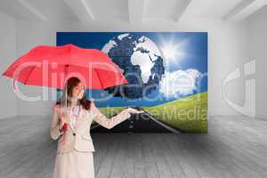 Composite image of attractive businesswoman holding red umbrella