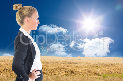 Composite image of businesswoman standing with hands on hips