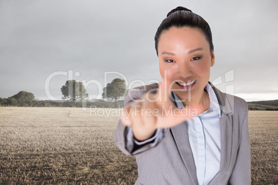 Composite image of smiling asian businesswoman pointing