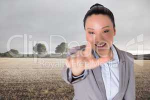 Composite image of smiling asian businesswoman pointing