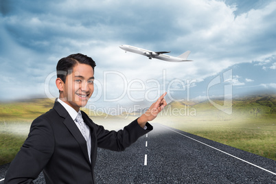 Composite image of smiling asian businessman pointing