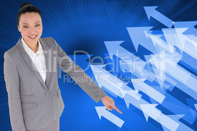 Composite image of smiling asian businesswoman pointing